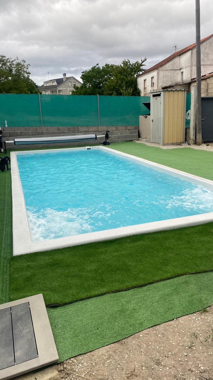 Piscina terminada de ILMAS rodeada de césped en un jardín