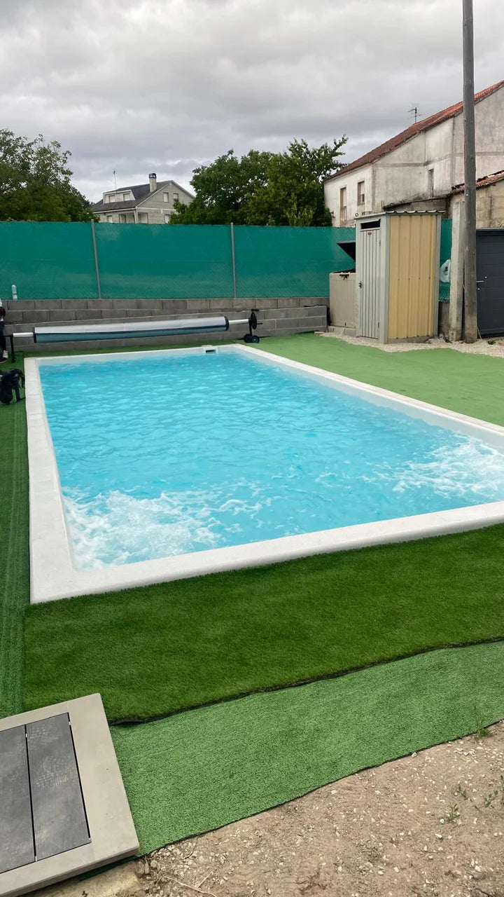 Piscina terminada de ILMAS rodeada de césped en un jardín